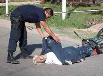 Un policía cubre el cuerpo del occiso. Atrás, su bicicleta.