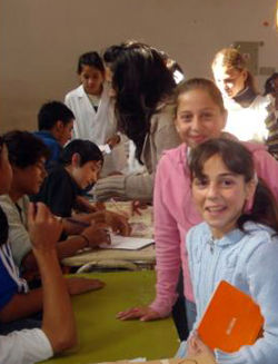 Dos chicas sonríen, mientras esperan para sufragar.