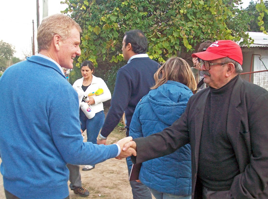 De Narváez saluda a un vecino al llegar al barrio Bedoya. Estuvo más de una hora en el lugar.